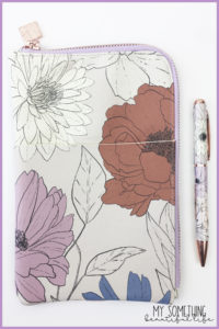 floral pen pouch with flowered pen sitting next to it